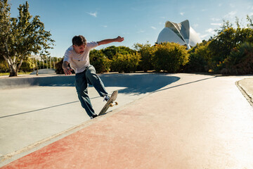 A young man doing tricks on his skateboard at the skate park. Active sport concept
