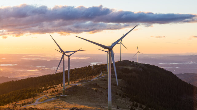 A group of wind mills on a mountain ridge in Austria during sunrise in Austria