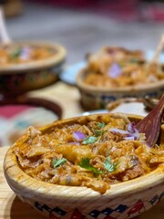 A traditional Algerian dish called “chakhchoukha bou saada” served in a wooden plate, with roasted chicken and salads. Ghardaïa. Oasis M'zab, Algeria.