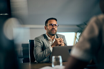 Focus on the businessman talking to a client, having a meeting in the meeting room. - 748770992