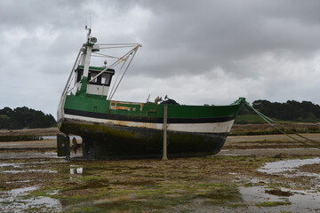 un bateau de pêche vert sur la plage