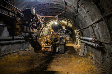 Coal mining underground with large machines and in long, dark corridors and tunnels 