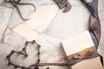 Father's Day Gift concept with copy space on a stone background with gift box, antique tools, and a chain formed into a heart shape.  