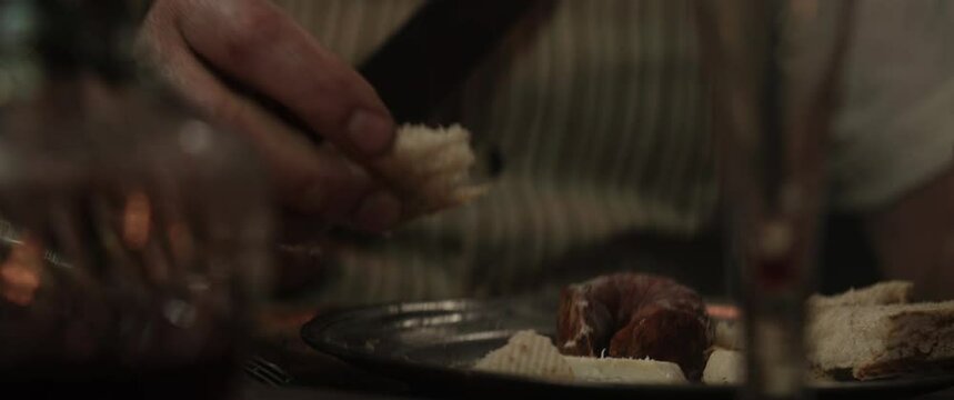 The old pirate grabs the bread from the silver plate inside the vintage ship cabin
