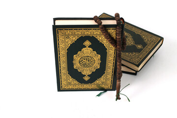 The Holy Quran with Arabic calligraphy, meaning The Noble Quran, and a tasbih, isolated on a white...