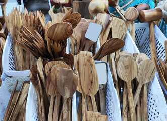 Wooden brown kitchen spoons for mixing food, on the shop window - obrazy, fototapety, plakaty