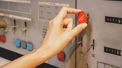 Engineer woman hand pull emergency button on old panel control of machine in factory, reset the...