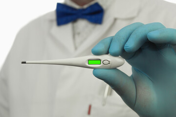 Electronic thermometer in the hands of a doctor, close-up. Chromakey. Copy space