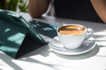 Morning work and a cup of hot coffee. A freelancer works in a coffee shop. Concept for content creator, blogger and SMM marketing