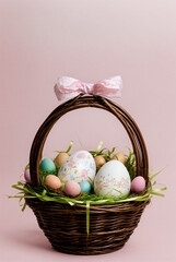 Colorfully decorated eggs in a basket,Happy Easter, pink background