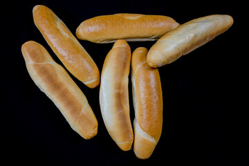 freshly baked bread roll on a black background, top view