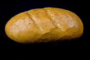freshly baked wholemeal bread on black background top view
