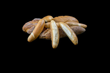 set of freshly baked pastries on a black background - bread, rye bread, rolls - top view