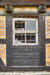 Old, broken window and exterior with cage or brick wall of abandoned house, building or wooden frame. Historic outdoor bunker of rubble, glass crack or damage from war wreck, destruction or vandalism