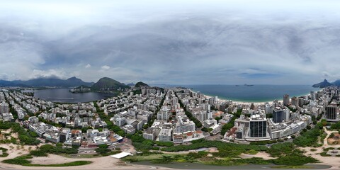 360 aerial photo taken with drone over large park in middle of Ipanema between lake and sea