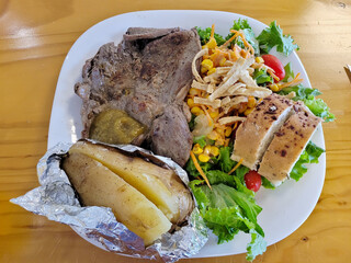 Juicy T-bone steak grilled to perfection, served with a hearty baked potato and a fresh side salad...