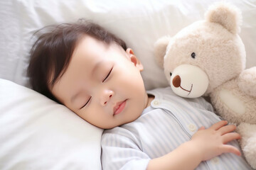 Obraz na płótnie Canvas A cute newborn asian baby sleeping on bed with a teddy bear