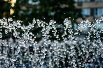 Outdoor fountain in hot weather. The drops froze in flight. Close-up.