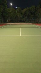 A close up photo of green tennis court with white line