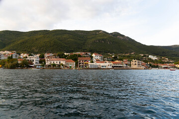 Fototapeta na wymiar Montenegro, Beautiful sea towns, Residential houses by the sea, view from the water.