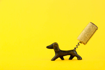 Close-up of a corkscrew in the form of a dachshund dog with a wine cork in the form of a tail On a...