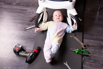 Boy mechanic repairs the suspension of a baby carriage. We repair everything that travels. Humor, challenge.