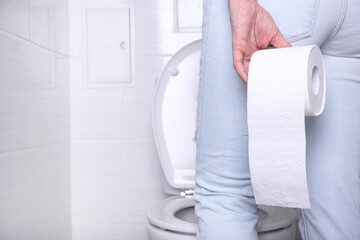 pissing woman suffering from diarrhea in a white toilet, in a toilet with a roll of white paper...