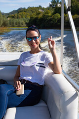 Happy caucasian beautiful woman on the pine forest of a luxury yacht. Pretty sexy fashion model. Montenegro, Lake Skadar.