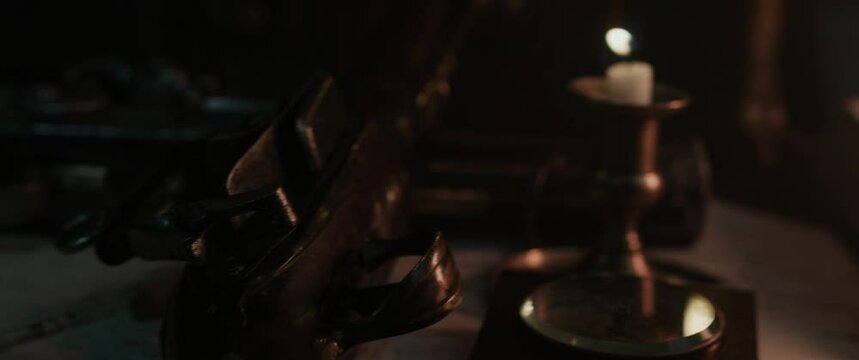 A wind blows off a candle inside the old pirate sailing ship cabin