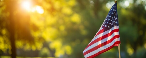 American flag with blurred trees and sunlight background. Memorial Day Celebration Concept.