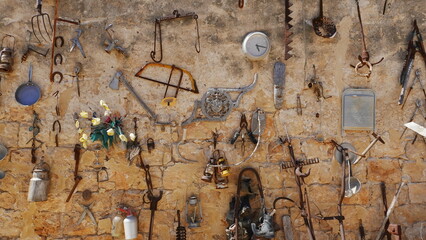 Antique Utensils on the Wall on a sunny day outside. Beautiful vintage background. Garden Decorative Decision