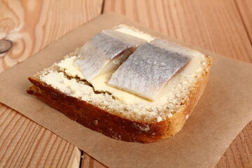 Sandwich with pickled herring and butter. Salted, soused skinless slices of fish Clupea.