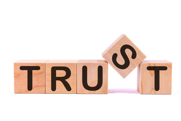 TRUST word concept written on wooden cubes on a light table and light background