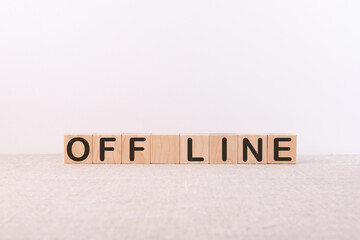 OFF LINE word concept written on wooden cubes lying on a light table and light background.