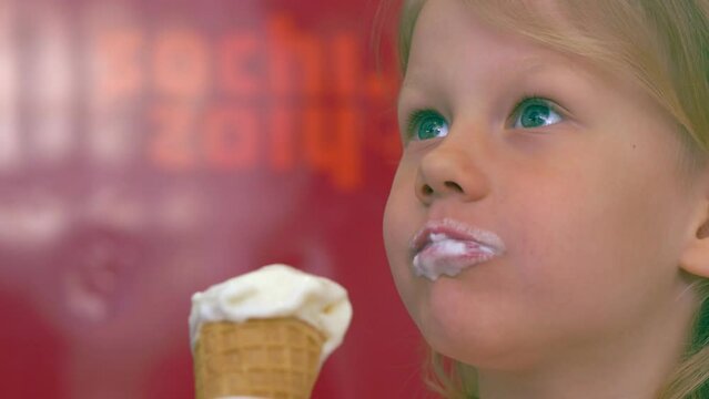 greedy baby girl - tender image of a little blonde girl eating ice cream