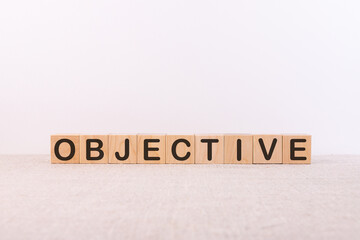 Fototapeta premium ObjectiveOBJECTIVE word concept written on wooden cubes lying on a light table and light background.
