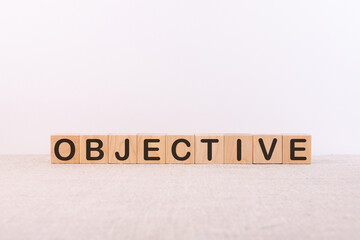 ObjectiveOBJECTIVE word concept written on wooden cubes lying on a light table and light background.