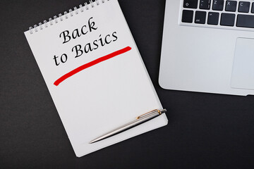 The text, the inscription, the phrase Back to Basics is written in a notebook that lies on a dark...