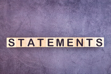 STATEMENTS word made with wood building blocks.