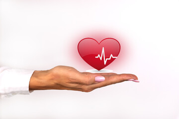 Health, medicine, people and cardiology concept - female hand with a cardiogram on a small red heart