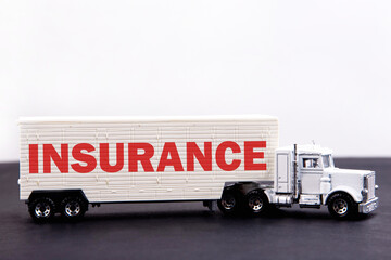 Insurance word concept written on board a lorry trailer on a dark table and light background