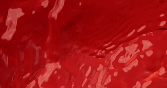 Super slow motion macro of red paint liquid surface with moving waves at 1000 fps.