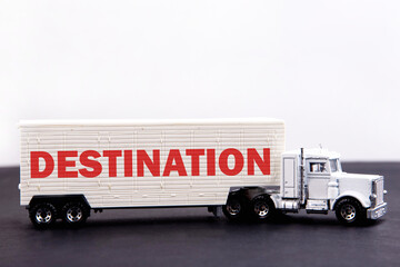 Destination word concept written on board a lorry trailer on a dark table and light background