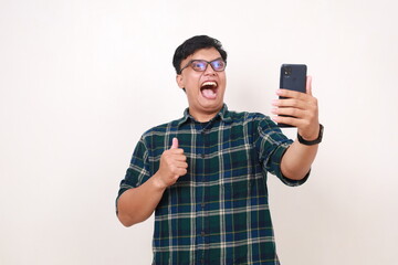 Wow excited face expression of young asian man while getting good news from his phone