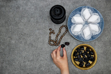 eid al fitr or aldha, ramadan concept iftar and breakfast. makrout algeria cookies made from almond paste and covered with icing powder, hand hold Ajwa dates, lantern and rosary beads