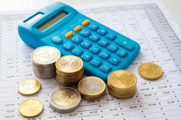 Calculator and coins above budget calculation table.
