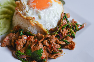 Pork with basil and fried egg on rice is ready to eat on the table.