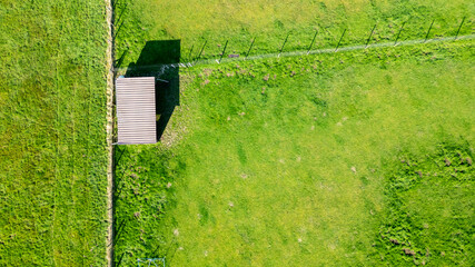 This aerial photograph captures a solitary small shed with a gabled roof in the middle of a vibrant...