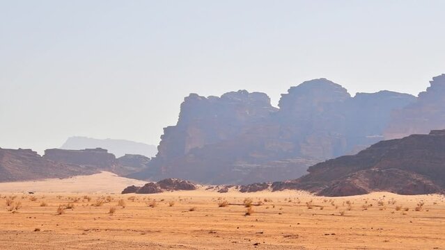 Jordan -15th october, 2022: Wadi rum desert landscape with 4wd enter frame drive safari tour in hot day weather with stunning landscape background