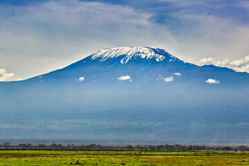 Mount Kilimanjaro dominates the views over the vast Amboseli national park savanna providing a picture perfect backdrop to a classical African scene.
